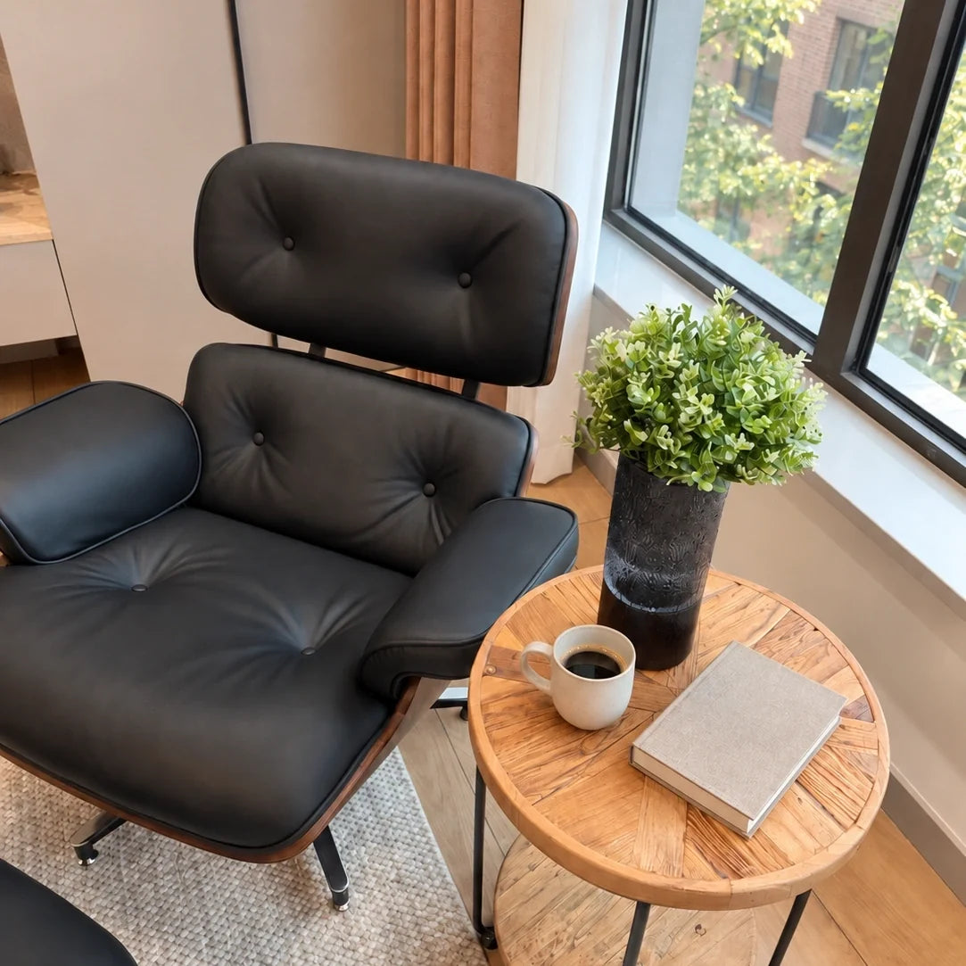 Black leather lounge chair beside a window with a book and coffee