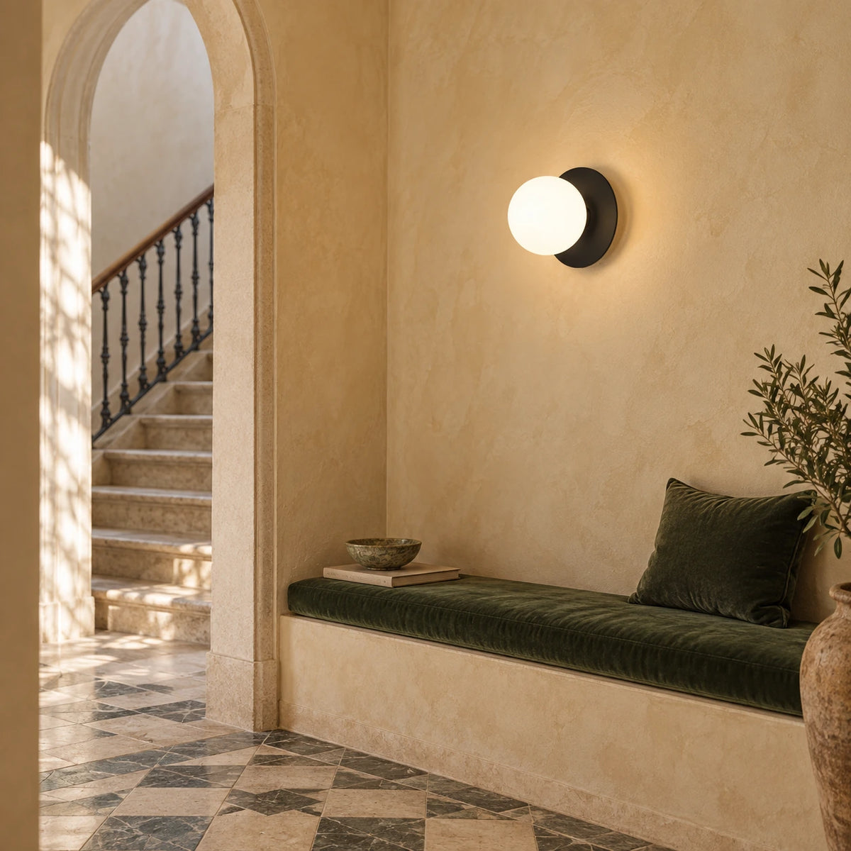 Black disc and single opal-globe wall light above an olive bench in an ochre stair landing