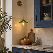 Green scalloped-glass hanging wall light in a cream-tiled kitchen corner