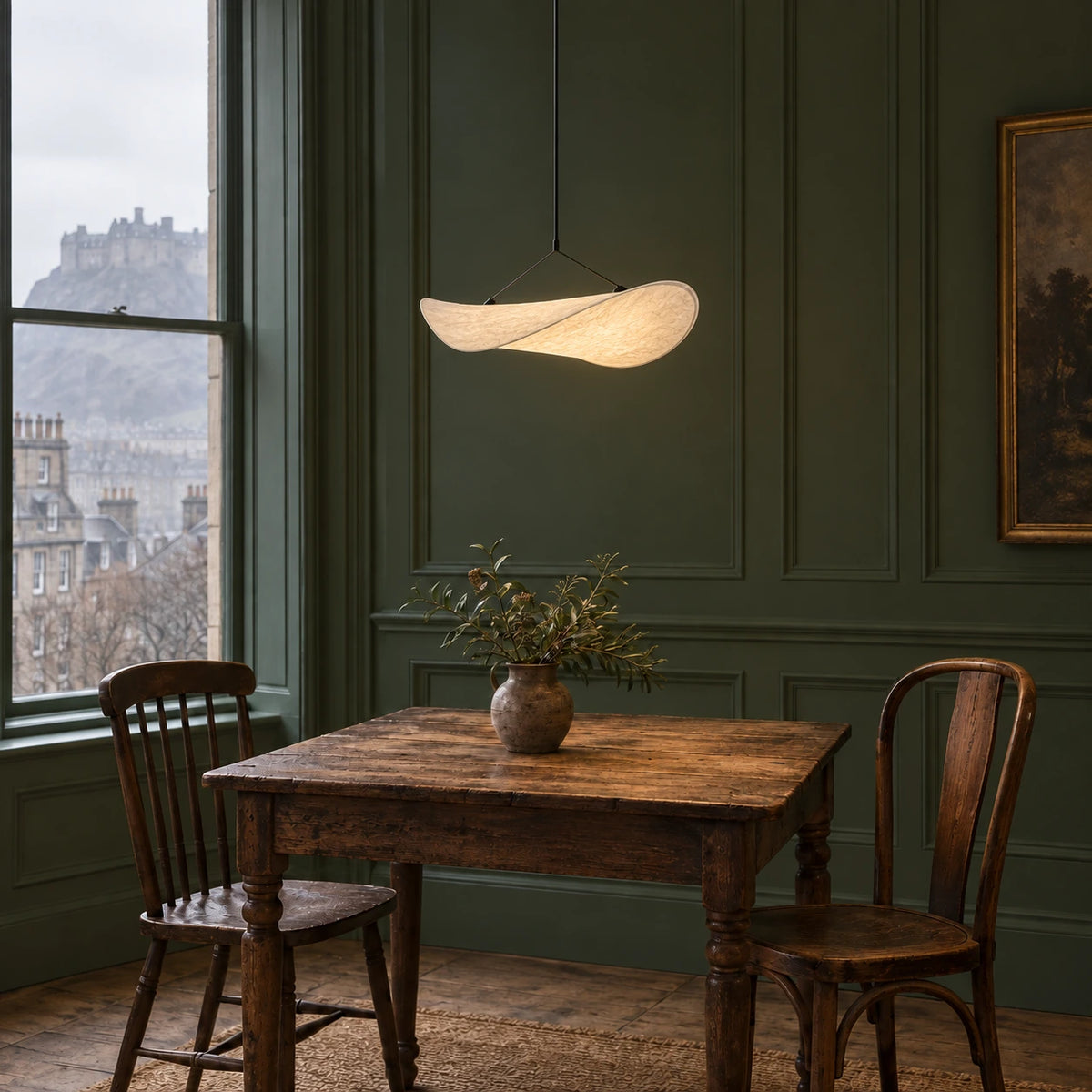 Single translucent curved fabric pendant over an oak table in an Edinburgh dining nook