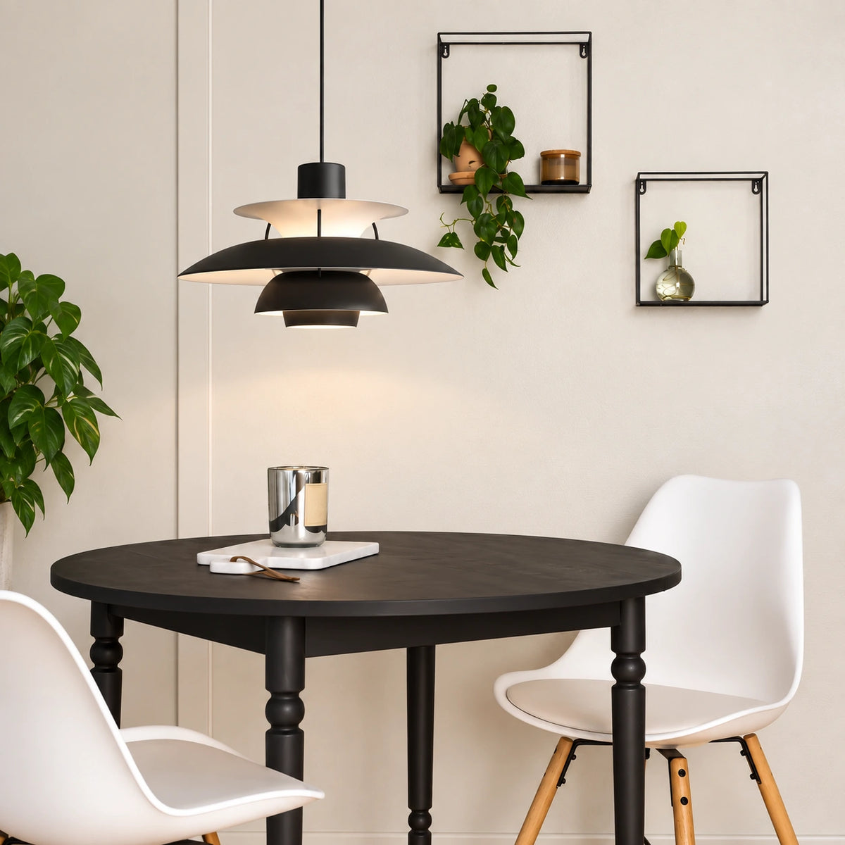 Layered Scandinavian Pendant Lamp in black above a round black dining table