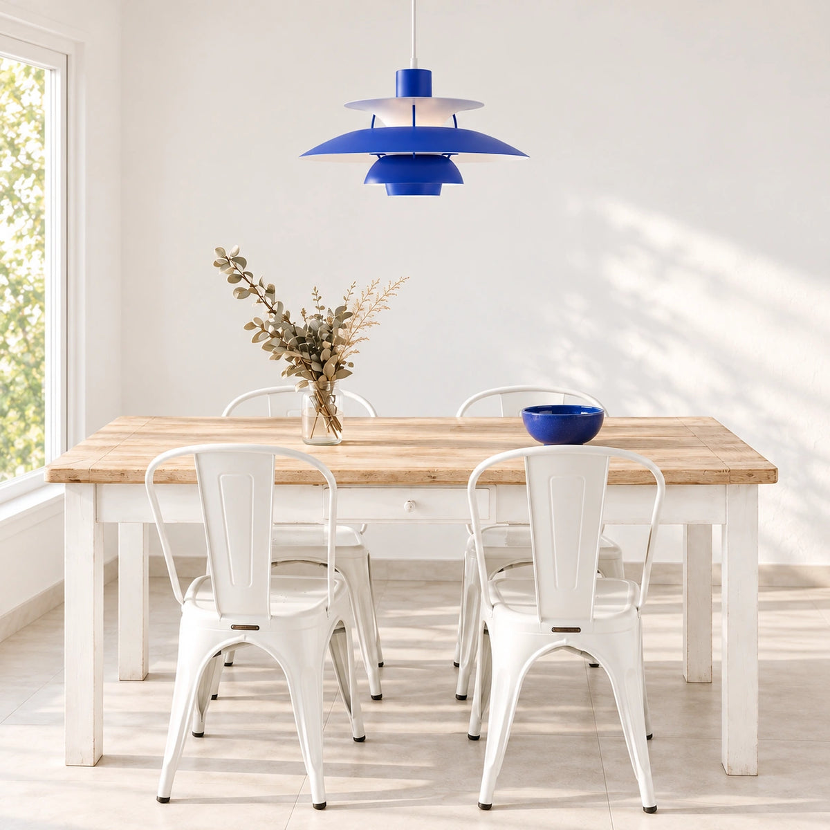 Layered Scandinavian Pendant Lamp in Klein Blue above a light wood dining table