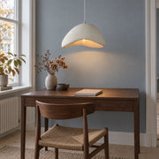 Single off-white asymmetrical resin pendant above a small Copenhagen writing desk
