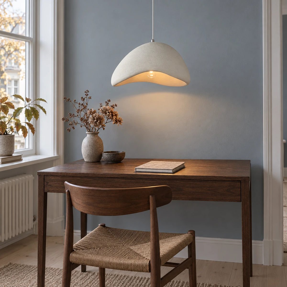 Single off-white asymmetrical resin pendant above a small Copenhagen writing desk