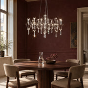 Silver branching crystal pendant above a round walnut dining table in a Vienna apartment