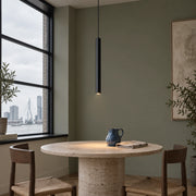 Single slim black cylinder pendant above a travertine breakfast table in a Rotterdam apartment