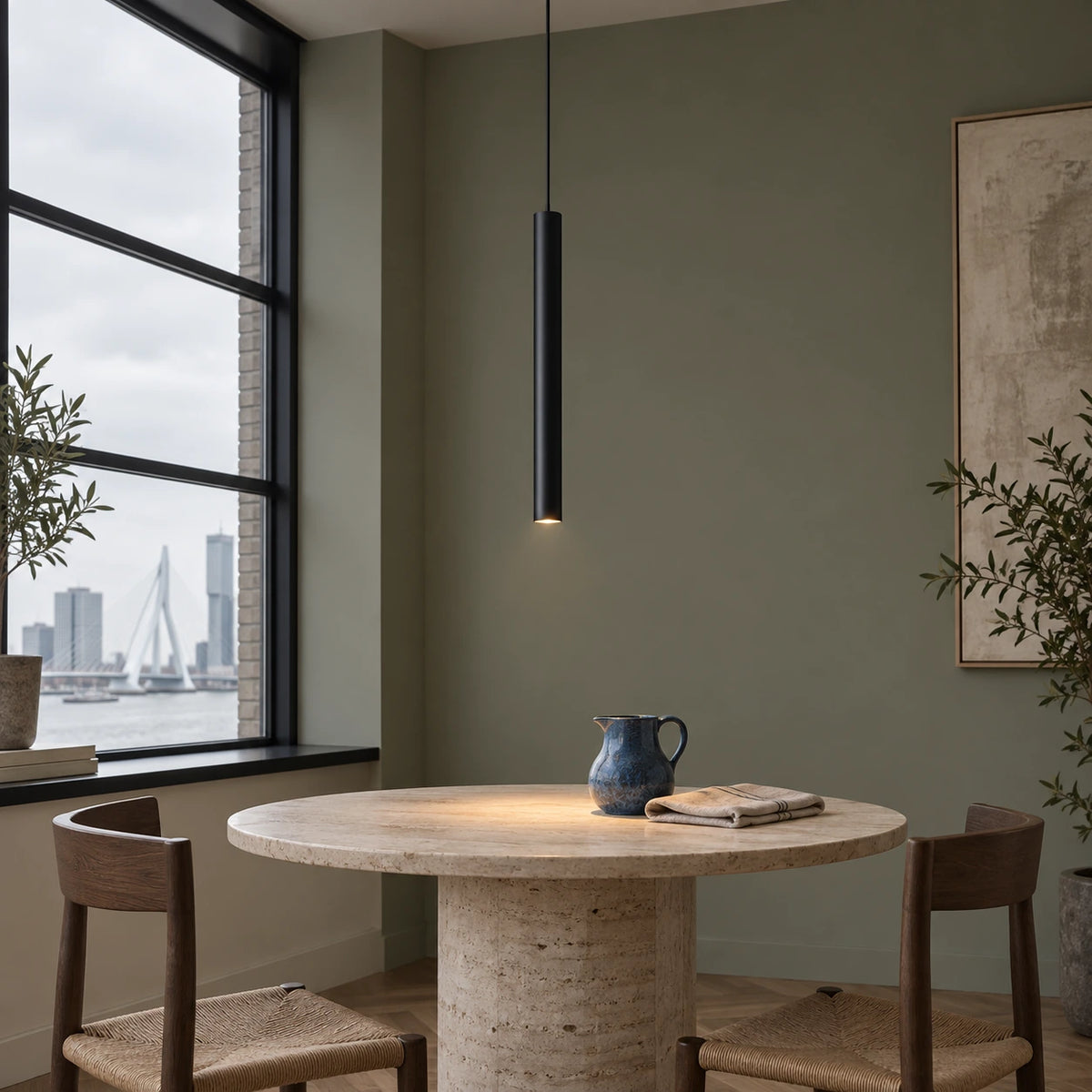 Single slim black cylinder pendant above a travertine breakfast table in a Rotterdam apartment