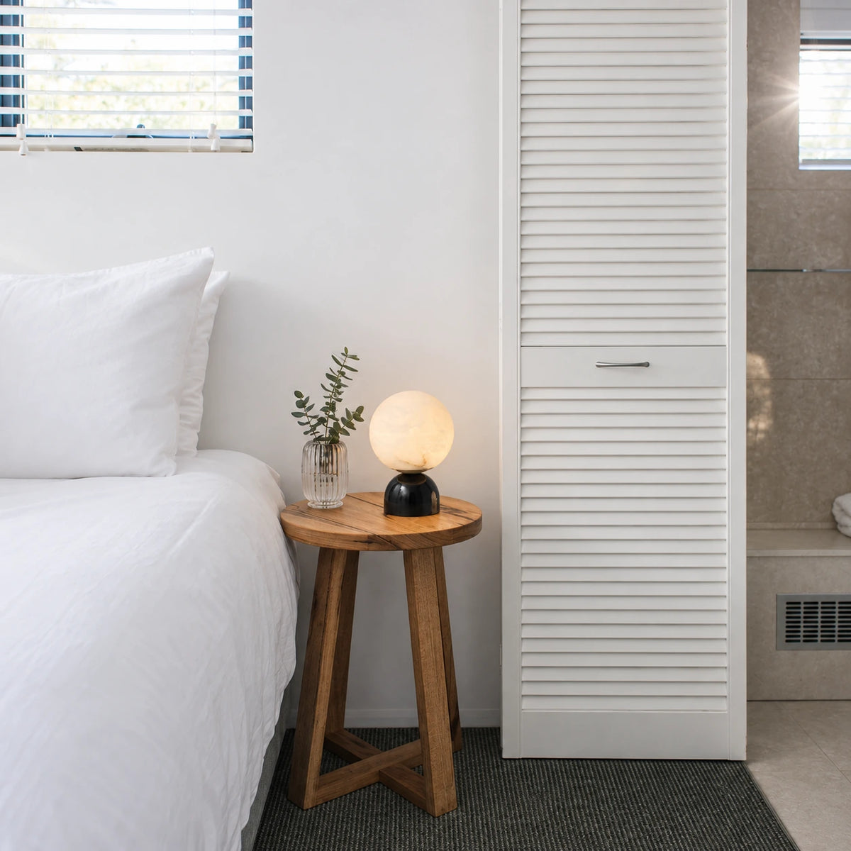 A compact glowing globe adds a soft focal point beside the bed.