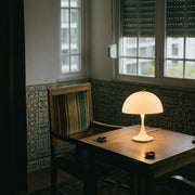 White Dome corded table lamp on a tiled reading-corner table by a shuttered window