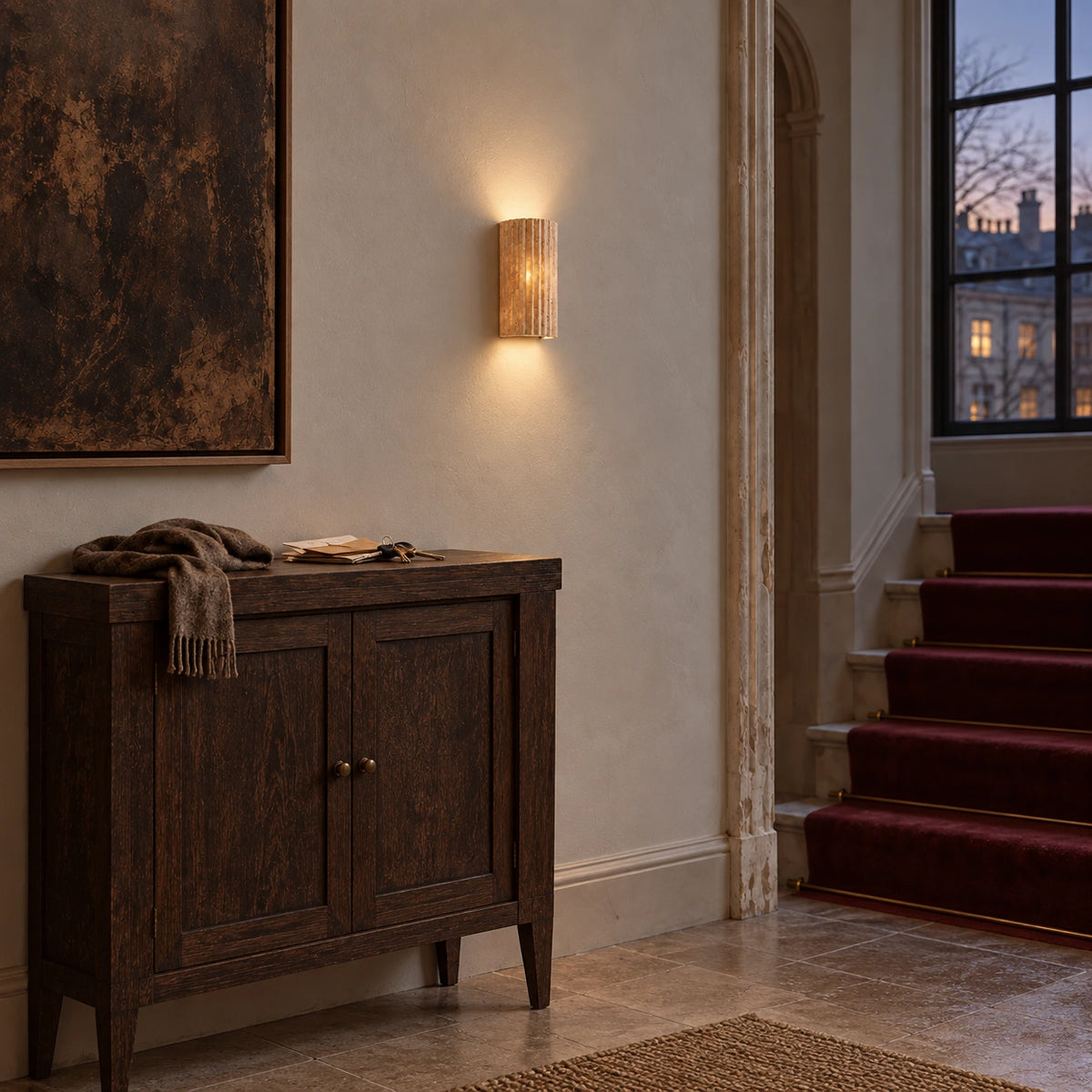 Small fluted half-cylinder stone wall light with a warm glow above a wooden cabinet